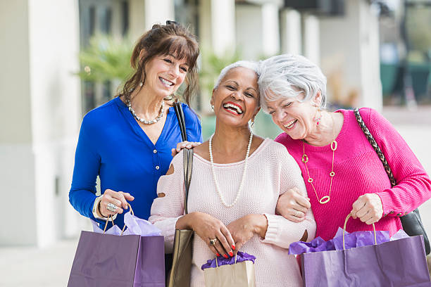 tre donne anziane multietniche fuori a fare shopping - bag senior adult outdoors friendship foto e immagini stock