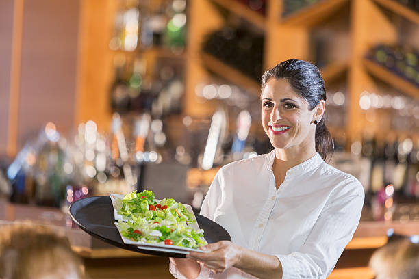 Waitress in restaurant serving food to customers