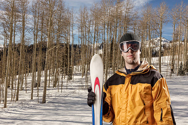 istock skier holding a pair of skis 615809382