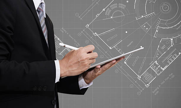 istock Businessman working on digital tablet with Architectural blueprint plan drawing 615811256