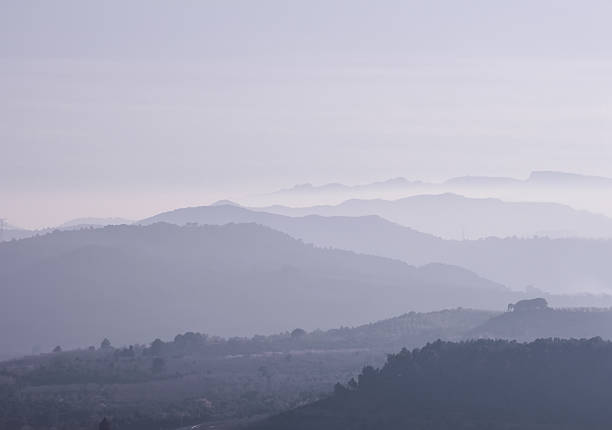 istock Mountains covered with heavy purple fog at sunset. 615811594