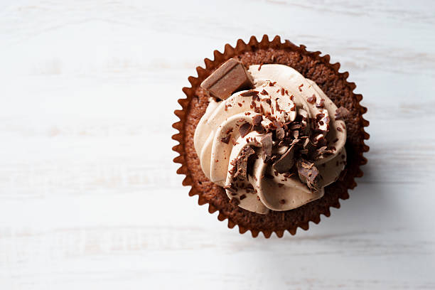 cupcake au chocolat avec tourbillon de crème au beurre de chocolat - cupcake chocolate icing candy photos et images de collection