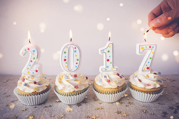 istock 2017 Happy New Year Cupcakes with fairy light toning background 615812670