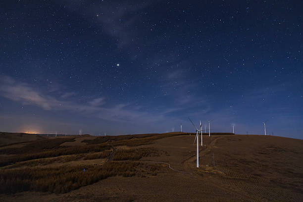 istock Wind power generator in the moonlight and stars 615813278