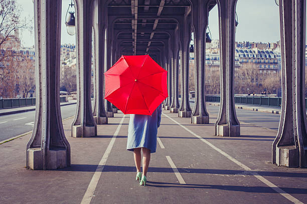 woman with red umbrella walking on the street of Paris fashion woman with red umbrella walking on the street in Paris paris fashion stock pictures, royalty-free photos & images