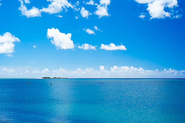 istock Canoe and small island floating in the blue waters Okinawa 615814298