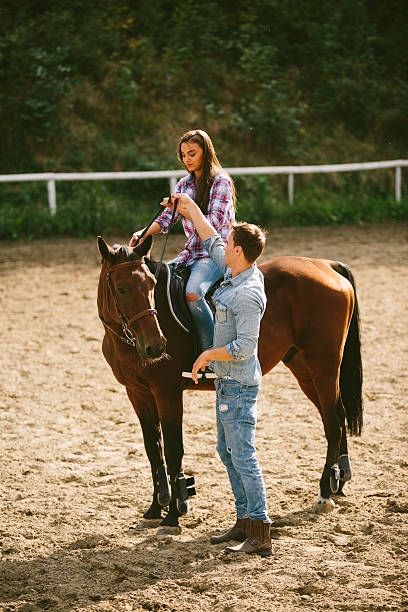 istock Young woman training horseback riding technique with instructor. 615815322