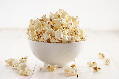 popcorn with caramel in a white porcelain bowl