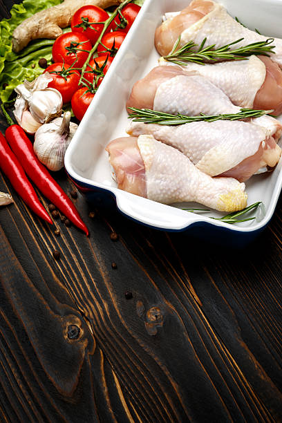 istock Raw chicken legs in baking dish on a wooden background 615818006