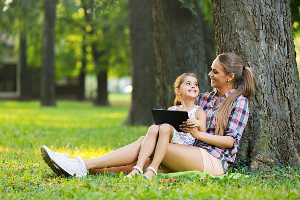 istock Mother and daughter using digital tablet in the park. 615819276