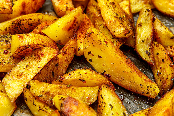 istock Baked potatoes with spices and salt baking sheet 615820302