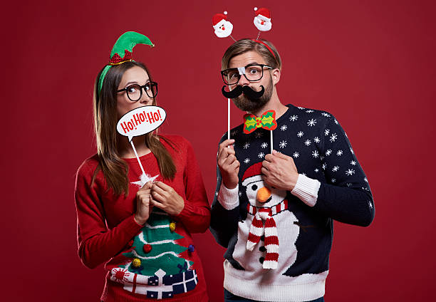 Boyfriend and girlfriend with Christmas masks Boyfriend and girlfriend with Christmas masks christmas nerd sweater cardigan stock pictures, royalty-free photos & images