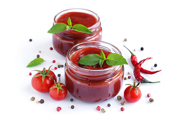 istock Tomato sauce and basil in glass jars 615822206