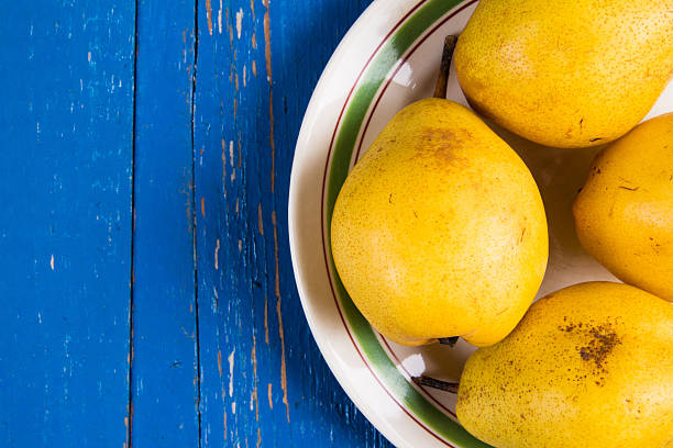 istock Fresh ripe organic yello pears on blue rustic wooden table 615823844