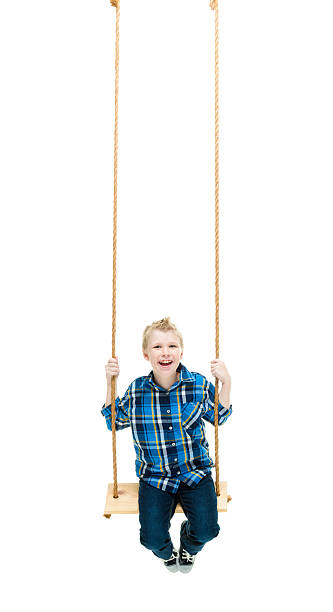 istock Smiling little boy swinging 615823972