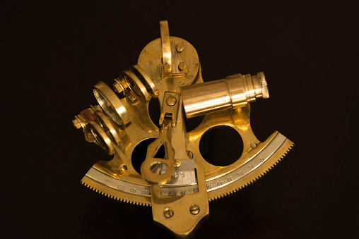 Vintage sextant, made of brass on black background