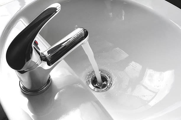 Faucet with Running Water in a Sink stock photo