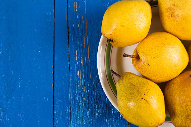 istock Fresh ripe organic yello pears on blue rustic wooden table 615826964