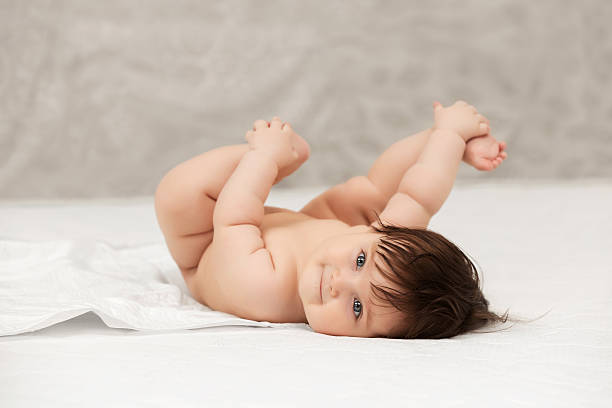 Baby girl lying on blanket indoors stock photo