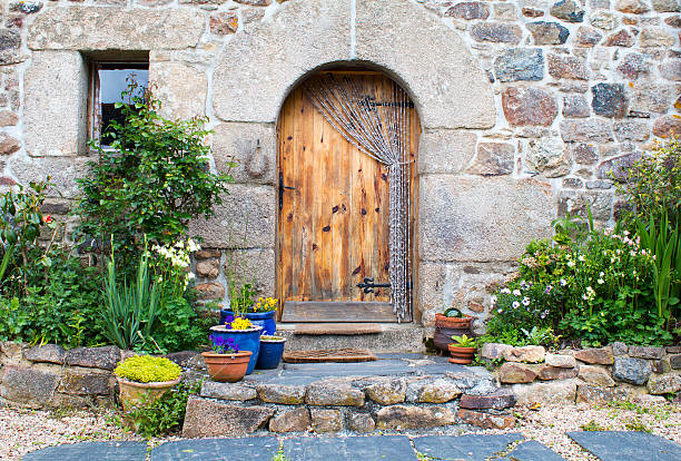 Rustic French gite doorway and window decorated with plants in Brittany France