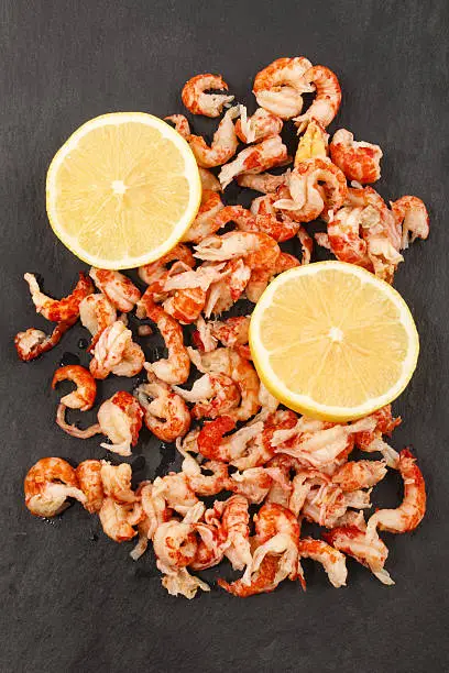 Photo of cleaned and cooked crayfish tails with lemon on slate