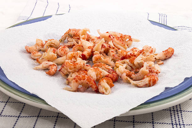 cleaned and cooked crayfish tails with white kitchen paper cleaned and cooked crayfish tails with white kitchen paper on a blue plate tail fin stock pictures, royalty-free photos & images