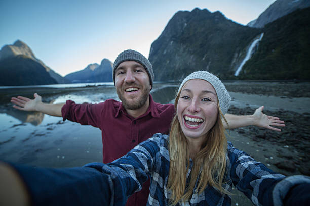 istock Playful couple take selfie with mountain landscape 615829556