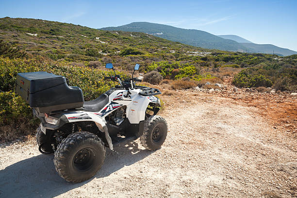 White ATV quad bike Aeon Overland 200 Zakynthos, Greece - August 20, 2016: White ATV quad bike Aeon Overland 200 stands parked on rural road. Popular tourist mode of transport on Greek islands horizon over land stock pictures, royalty-free photos & images