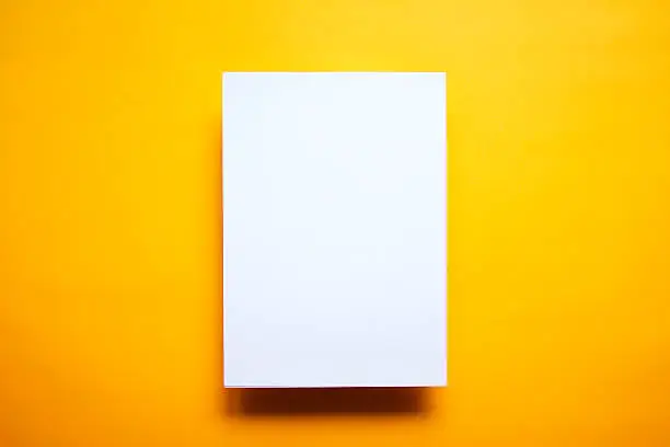 Photo of Empty white paper sheet isolated yellow background