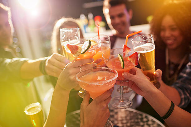 Ringing in the weekend Shot of a group of people toasting with their drinks at a nightclub disco dancing photos stock pictures, royalty-free photos & images