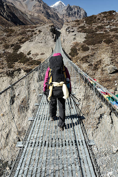istock hiker walking on a suspended metal bridge 615834200