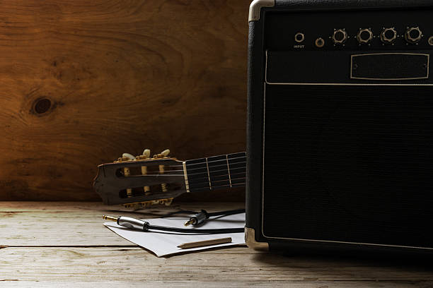 Guitar amplifier and guitar on wood table, light and shadow