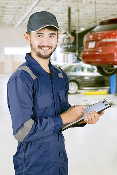 istock Asian mechanic with clipboard in workshop 615836972