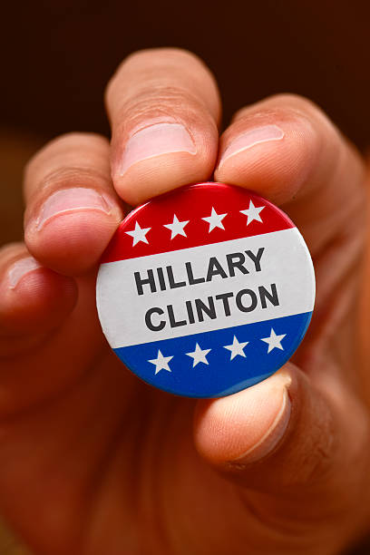 the name of Hillary Clinton in a campaign button Barcelona, Spain - August 26, 2016: Man showing a campaign button with the name of Hillary Clinton and the colors and the stars of the flag of the United States, for the 2016 Presidential Election hillary clinton stock pictures, royalty-free photos & images