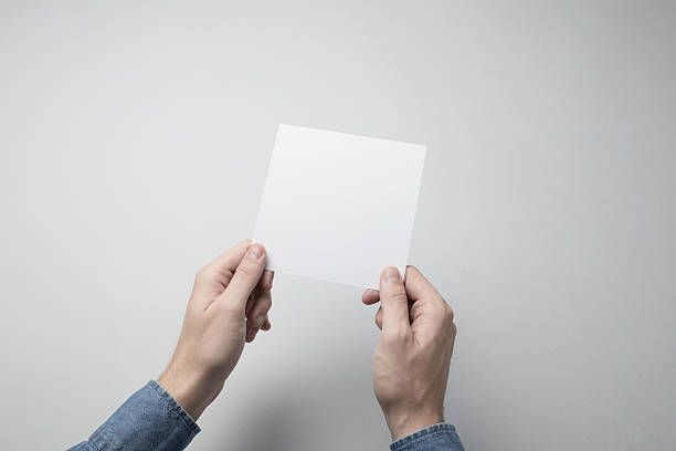 istock Hand holding Blank Square Flyer / Invitation Mock-up 615837780