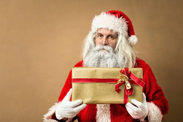 Photo of santa claus giving a golden present