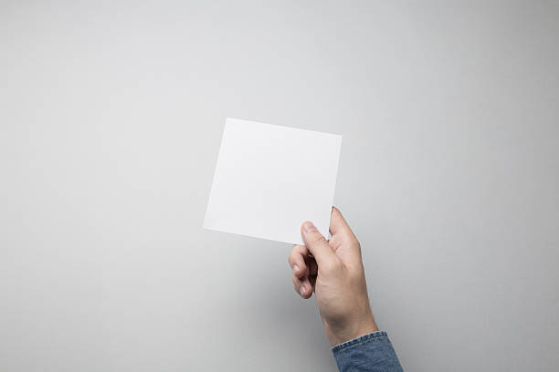 istock Hand holding Blank Square Flyer / Invitation Mock-up 615837922