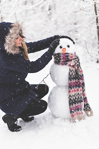 istock Young woman building snowman 615838346