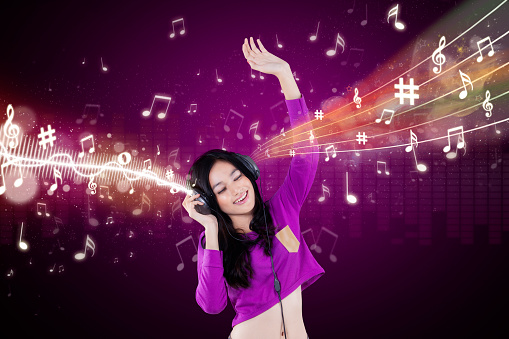 Young woman listen music while dancing and singing with rhythm of melody in the sky