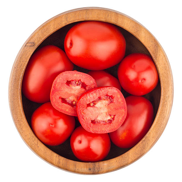 istock fresh tomatoes in wood bowl on white background. Top view. 615841128