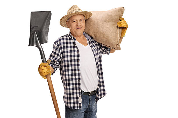 istock Elderly farmer posing with shovel and burlap sack 615881856