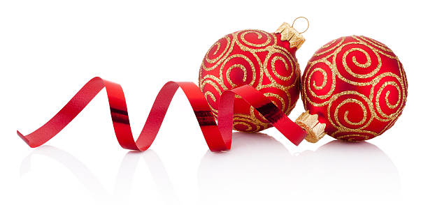 Red christmas baubles and curling paper isolated on white background