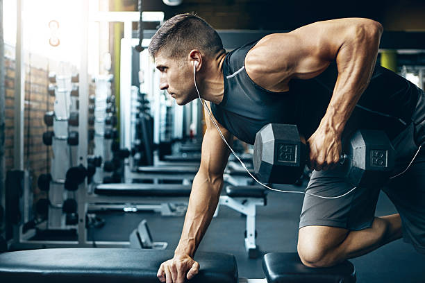 Difficult doesn’t mean impossible! Shot of a man doing weight training at the gym muscular build stock pictures, royalty-free photos & images