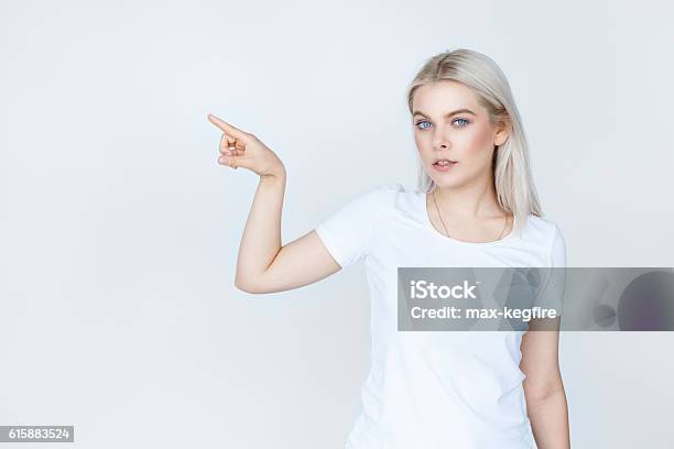 Teenage Girl In White Tshirt Pointing Finger Away Stock Photo - Download Image Now - White People, T-Shirt, White Color