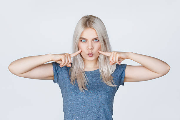 istock Young woman with fingers pointing to her dimples 615883668