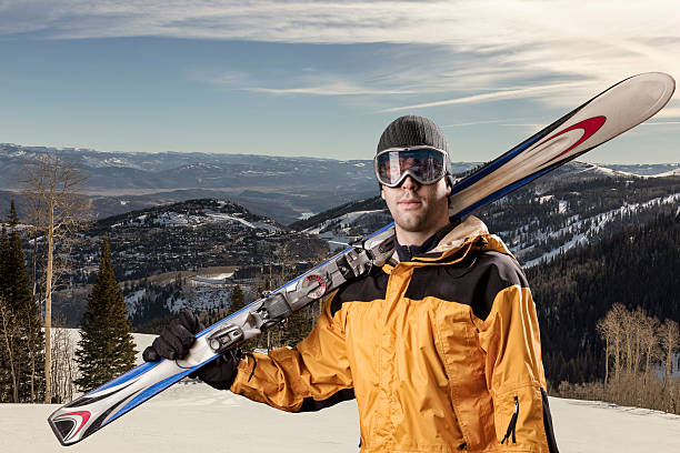 istock skier holding a pair of skis 615884202