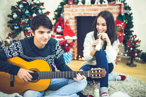 happy Young romantic couple siting in front of fireplace at winter season in home