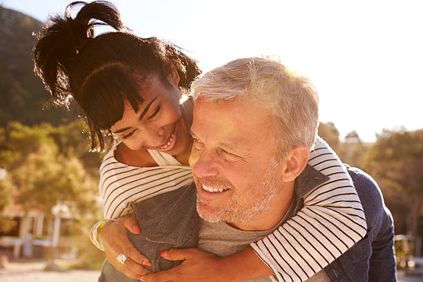 istock Middle aged couple lying on the beach making a toast 615885456
