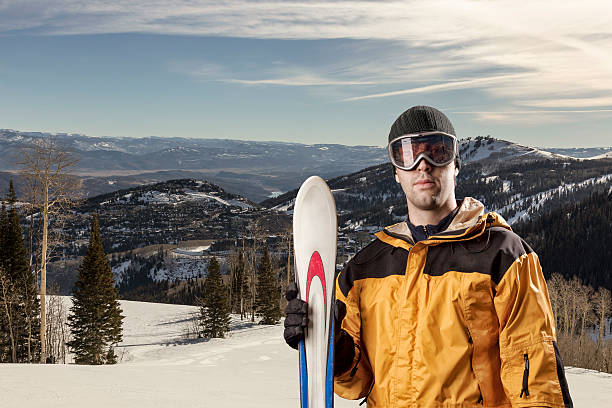 istock skier holding a pair of skis 615885536