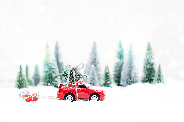 floresta de inverno com carro vermelho em miniatura carregando uma árvore de natal - schneelandschaft - fotografias e filmes do acervo